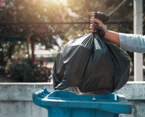 Man throwing away garbage in trash can